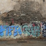 A homeless man walks past graffiti that reads “FIFA go home” in Rio de Janeiro